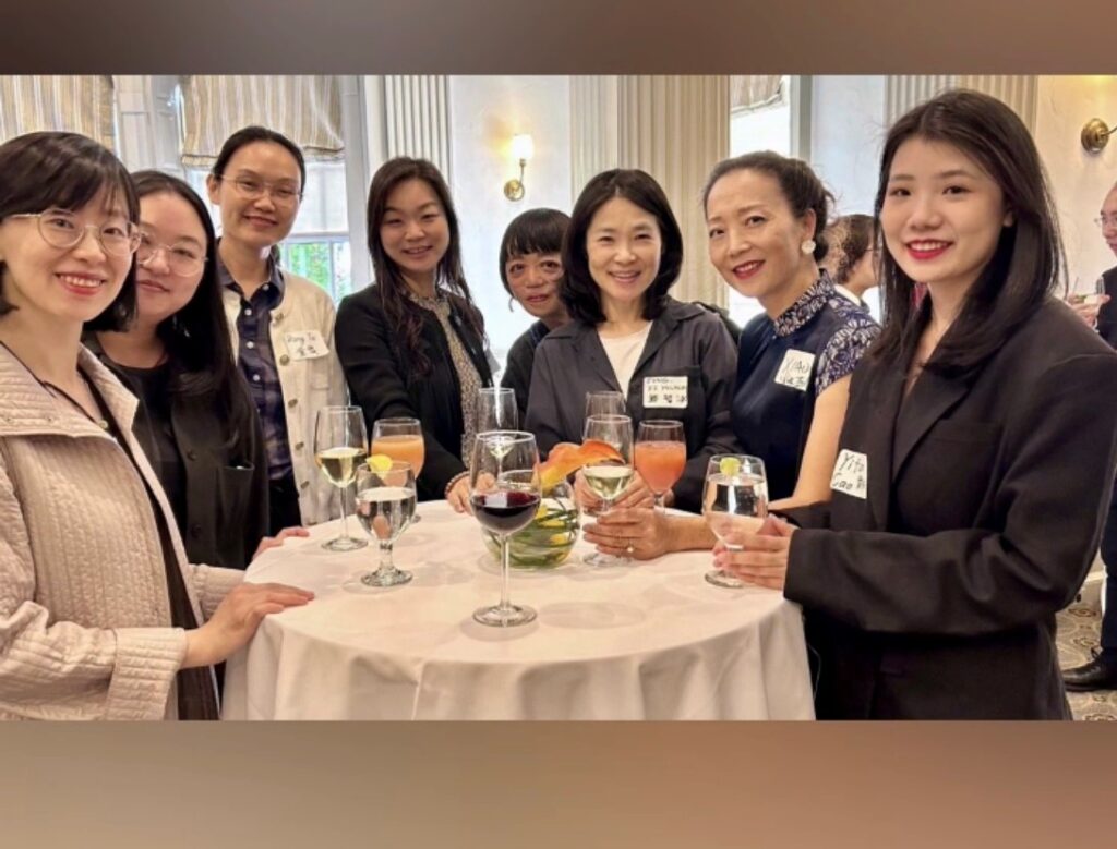 8 people stand around a small table at a reception